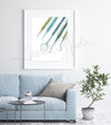 Framed watercolor print of dental hygienist tools. The painting is hanging over a white couch.