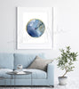 Framed watercolor painting of an eardrum. The painting is hanging over a blue couch.