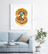 Framed watercolor painting of a kidney dissection in yellows, oranges, and teals. The painting is hanging over a blue couch.