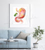 Framed watercolor painting of a stomach, duodenum, and gallbladder combination. The painting is hanging over a blue couch.