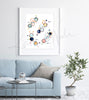 Framed watercolor poster of the molecular structure of reproductive hormones. The painting is hanging over a blue couch.