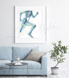 Framed watercolor painting of a runner, showing the skeletal structure beneath. The painting is hanging over a blue couch.