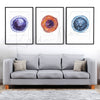 Framed watercolor painting set of stem cells. The painting is hanging over a gray couch.